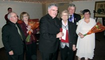 Bishop Wingle presents Mary Flaxy with a gift certificate and flowers in recognition of her 100th birthday later on in August.  Mike and Bannet Carroll and Des and Isobel Kennedy look on.
